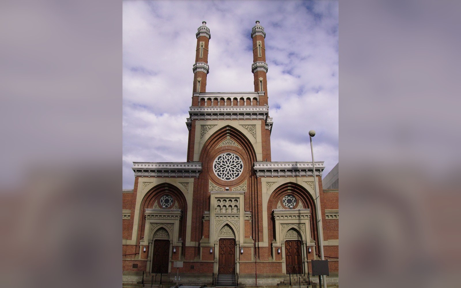 Twin minaret towers flank the arched brick facade of Plum Street Temple with a rose window