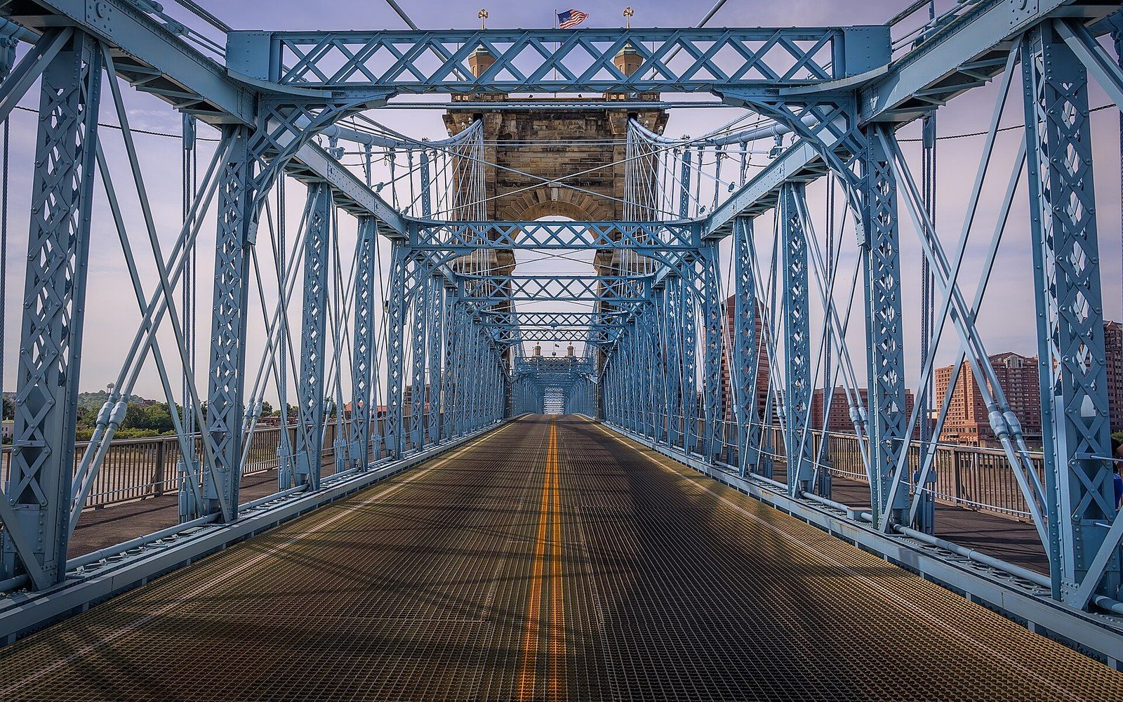 Roebling Suspension Bridge main cable in extreme close crop, individual wires visible, bridge tower out of focus behind